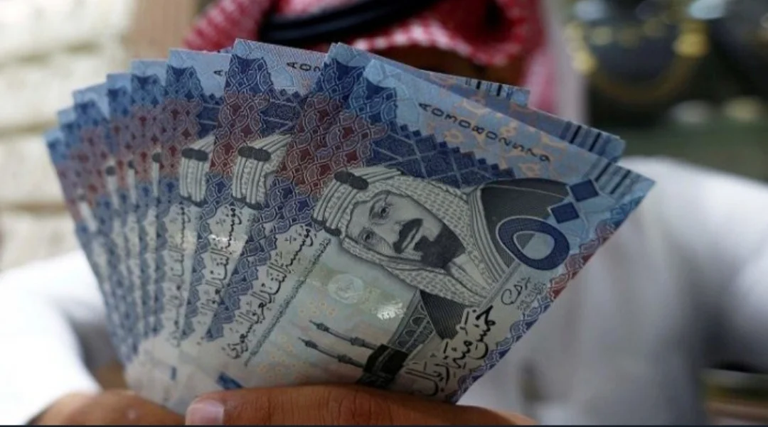 رجل ممسك بريالات